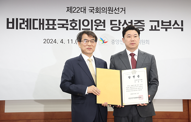 제22대 국회의원선거 비례대표에 당선된 국민의미래 진종오 당선인(오른쪽)이 중앙선거관리위원회에서 열린 비례대표 당선증 교부식에서 노태악 위원장에게 당선증을 받고 기념 촬영을 하고 있다. 사진=연합뉴스 제공