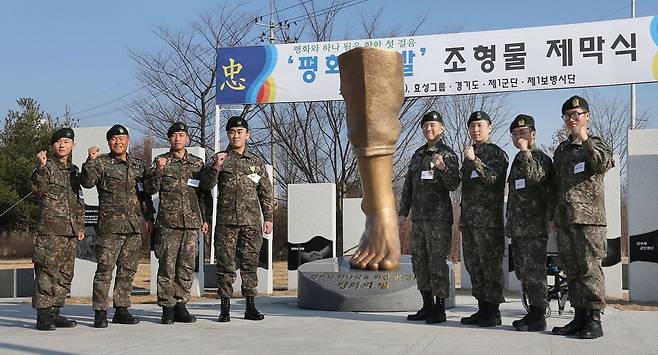 2015년 겨울 파주 임진각 평화누리 공원에서 열린 '평화의 발' 제막식에 참석한 1사단 수색대 작전팀. 왼쪽에서 네번째가 두 다리에 의족을 한 하재헌(21) 중사, 다섯번째가 한쪽 의족을 한 김정원(23) 중사. 맨 오른쪽이 박준호(22) 병장이다. 이들은 매년 8월 모임을 갖는다고 한다. /연합뉴스