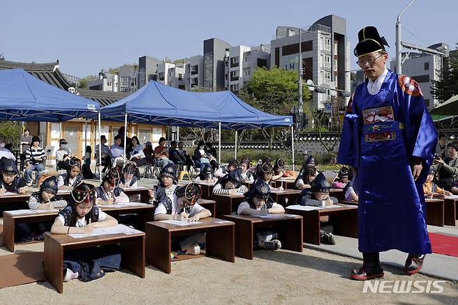 [서울=뉴시스] 최동준 기자 = 13일 서울 강남구 못골한옥어린이도서관에서 유생복장을 한 어린이들이 과거시험 방식으로 독서경연을 하고 있다. 2024.04.13. photocdj@newsis.com