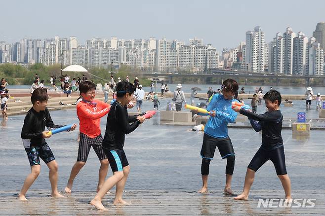 [서울=뉴시스] 조성봉 기자=  때 이른 더위가 찾아온 14일 오후 서울 여의도 한강공원 물빛광장에서 어린이들이 물총싸움을 하며 더위를 식히고 있다. 2024.04.14. suncho21@newsis.com