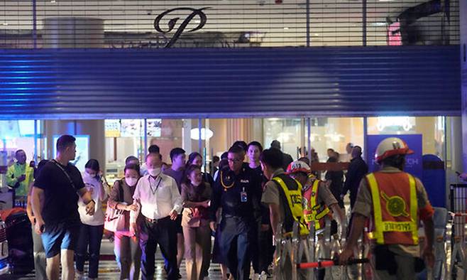 지난 2023년 10월 3일 태국 방콕 쇼핑몰 시암 파라곤에서 총격사건이 벌어져 쇼핑객들이 대피하고 있다. AP뉴시스