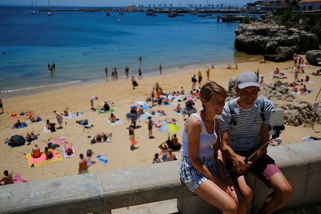 포르투갈의 한 해변에서 사진을 찍고 있는 관광객들. /연합뉴스