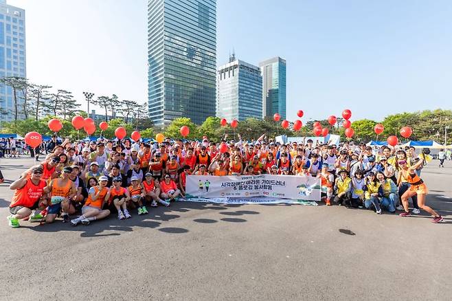 OCI홀딩스 임직원과 시각장애인들이 지난 14일 서울 여의도 한강공원에서 열린 '소외계층돕기 제11회 행복한가게 마라톤대회'에서 완주 후 기념촬영을 하고 있다. OCI홀딩스 제공