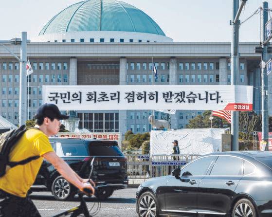 12일 오후 서울 여의도 국회의사당 앞에서 국민의힘이 설치한 현수막이 걸려있다. 최기웅 기자