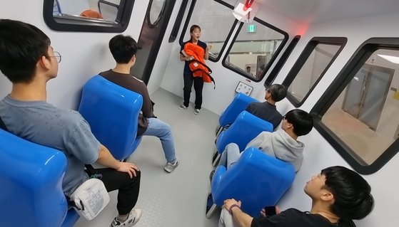 지난 12일 오후 전남 고흥군 점암중앙중학교 학생들이 전남 진도군 임회면 국민해양안전관에서 모형 선박 내 의자에 앉아 침몰시 배의 기울기 변화를 체험하고 있다. 황희규 기자