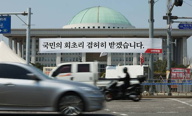 지난 12일 서울 여의도 국회의사당 앞에서 국민의힘이 설치한 현수막이 걸려있다. 연합뉴스