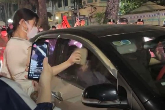 베트남의 한 도로에서 남편이 차에 불륜 상대를 태웠다고 의심한 아내가 차창을 벽돌로 내려치는 모습. 사진 SNS 캡처