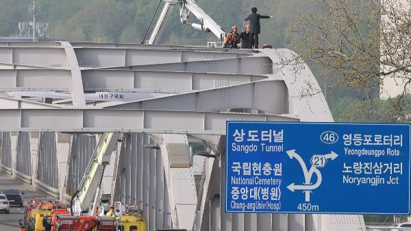 한 남성의 투신 소동으로 한강대교 일대 도로가 정체됐다. 사진은 한강대교 아치 구조물 위에서 소방과 대치 중인 한 남성. /사진=뉴스1