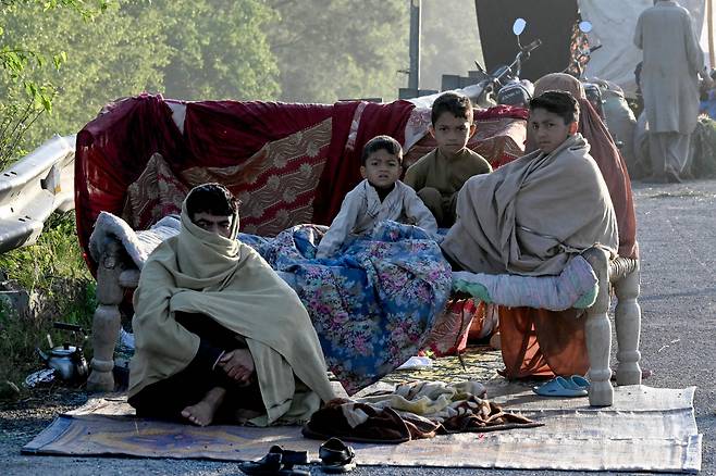 17일(현지시간) 파키스탄 카이버 파크툰크화주 차르사다 지역에 폭우가 내린 후 한 이재민 가족이 홍수 피해 주택을 피해 임시 수용소에서 텐트에서 구조를 기다리고 있다. [연합]