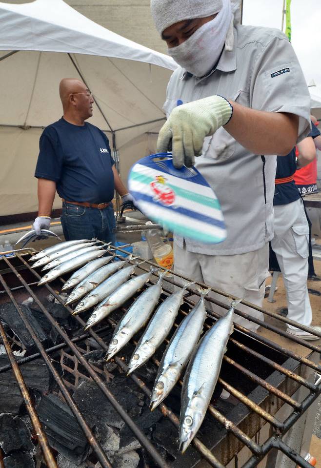 일본 북부 이와테현에서 열린 한 축제에서 어부가 꽁치를 굽고 있다(사진 : AFP)