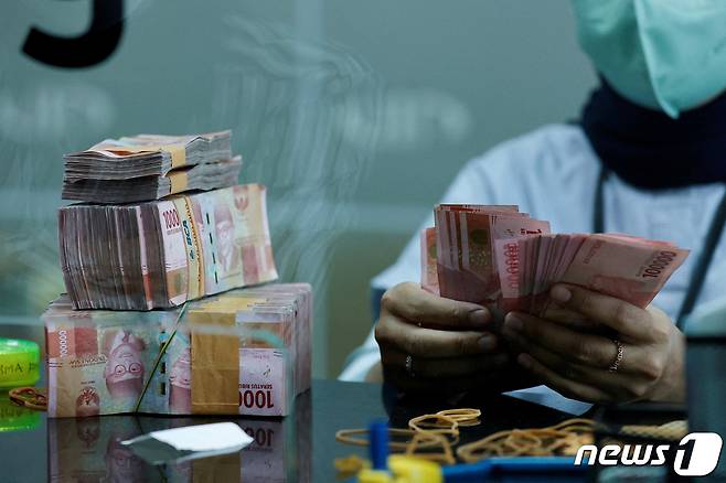 인도네시아 자카르타의 한 환전소에서 한 창구 직원이 인도네시아 루피아 지폐를 세고 있다. ⓒ 로이터=뉴스1 ⓒ News1 권진영 기자