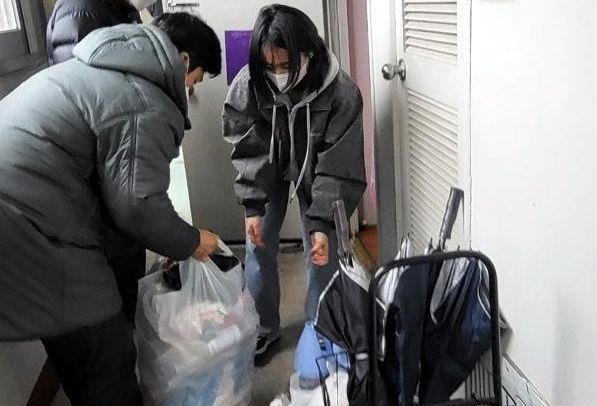 A씨 집앞 쓰레기 치우는 경찰관들 / 연합뉴스