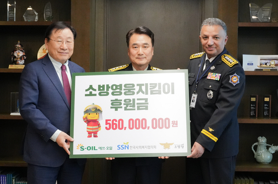 S-Oil CEO Anwar Al-Hejazi, right, Nam Hwa-young, center, head of National Fire Agency, and Korea National Council on Social Welfare Chairman Kim Sung-i take a photo after the oil refiner's donation of 560 milion won at the company's headquarters in Mapo District, western Seoul, on Friday. [S-OIL]