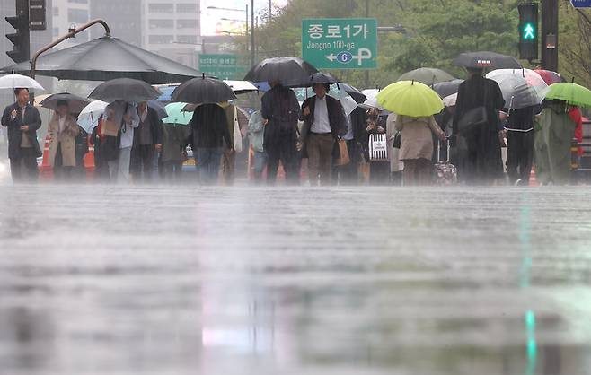 서울 등 중부지방에 오후까지 강수가 예보됐던 지난 15일 오전 서울 광화문광장에서 시민들이 우산을 쓰고 있는 모습. [사진 출처 = 연합뉴스]