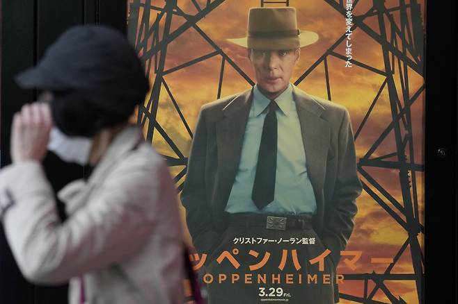 29일 일본 도쿄에서 한 시민이 영화 '오펜하이머' 홍보 포스터 옆을 지나고 있다. /사진 = (도쿄=AP/뉴시스) /사진=민경찬