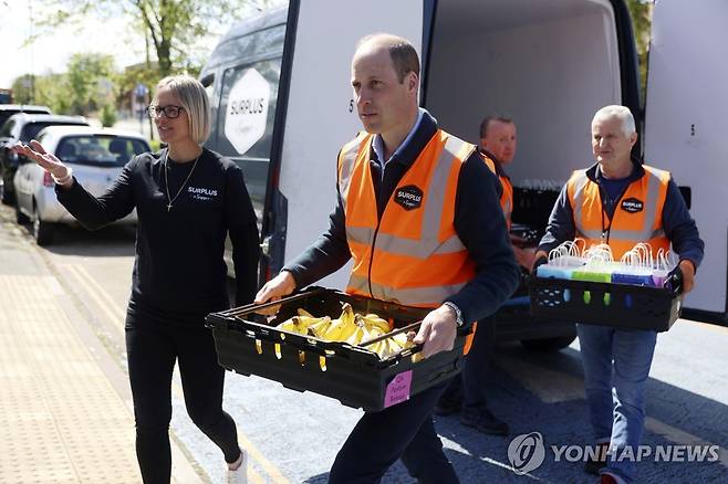 (런던 AP=연합뉴스) 윌리엄 왕세자가 18일(현지시간) 런던의 한 청년센터로 음식을 나르고 있다. 2024.4.18