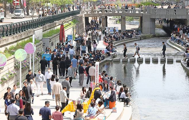 People read books at an outdoor library, which opened along the Cheonggye Stream in central Seoul on Thursday. (Yonhap)