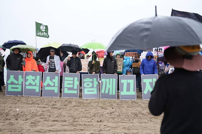 기후위기비상행동 회원들이 20일 삼척 근덕면 맹방해변에서 삼척블루파워 가동을 규탄하는 시위를 하고 있다. 녹색연합 제공