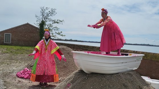 안은미의 '핑키 핑키 굿: 산 자코모의 내일을 향한 도약'은 배 위에서 돌을 하나씩 분홍 페인트에 적셔 새로 쌓아올리는 퍼포먼스로 마무리됐다. 베니스= 권근영 기자
