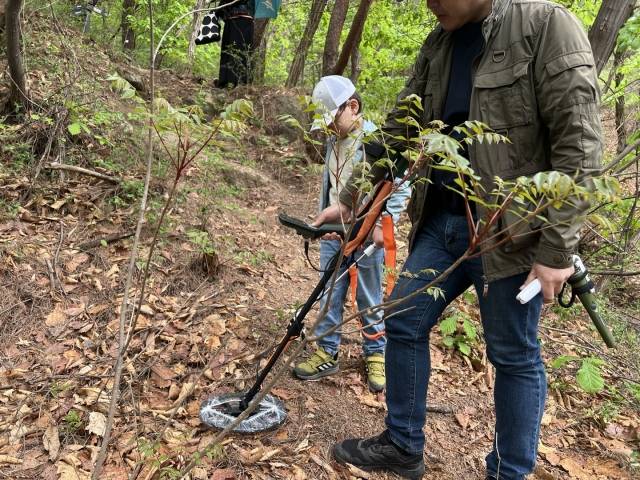 김한준군이 아버지 김현철씨와 함께 지난 20일 서울 서대문구 인왕산에서 금속탐지기로 땅속에 묻힌 금속을 찾고 있다. 김재환 기자