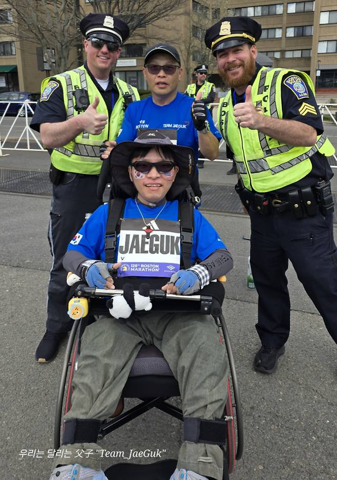 제128회 보스턴마라톤에 참가한 배종훈·재국씨(앉은 이) 부자의 사진 촬영에 응한 현지 경찰/사진=배종훈씨 제공