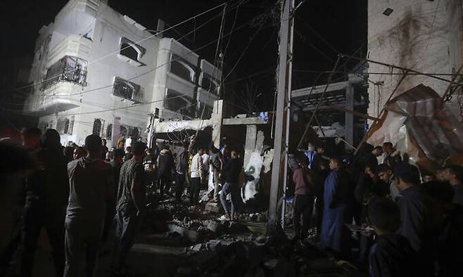 지난 17일(현지시각) 가자지구 남부 라파 난민촌에서 팔레스타인 주민들이 이스라엘의 공습으로 파괴된 주거용 건물 잔해를 살피고 있다. AP뉴시스