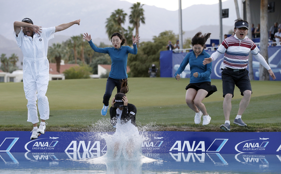 Ryu So-yeon, front center, leaps into the pond, followed by her caddie, Tom Watson, left, and family members after Ryu won the ANA Inspiration on a playoff hole at Mission Hills Country Club in Rancho Mirage, California on April 2, 2017. [AP/YONHAP]