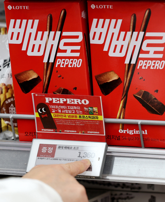 A person points to the price of Pepero, a chocolate snack made by Lotte Wellfood, at a supermarket in downtown Seoul on April 18. Lotte Wellfood will hike the prices of 17 chocolate snacks and ice cream products by an average of 12 percent amid record-high cocoa prices. [NEWS1]