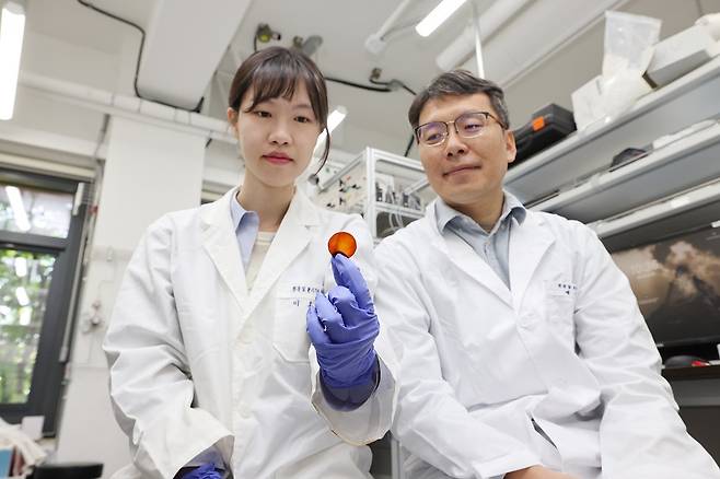 배태현(오른쪽) KAIST 생명화학공학과 교수 연구팀이 개발한 고성능 이산화탄소 분리막을 들어보이고 있다.[KAIST 제공]