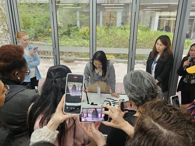 16일 서울 용산구 한글박물관을 찾은 외국인들이 캘리그라피를 쓰는 모습을 지켜보고 있다. [사진=박준이 기자]