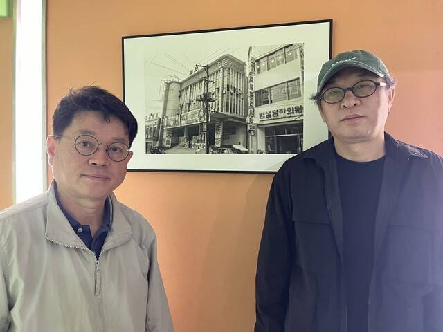 한국전쟁으로 부서진 뒤 전쟁이 끝나고 같은 자리에 다시 지어진 애관극장 자료 사진 앞에서 포즈를 취한 윤기형 감독(오른쪽)과 ‘애관극장을 사랑하는 시민모임’ 대표 이희환 박사. 김은형 기자