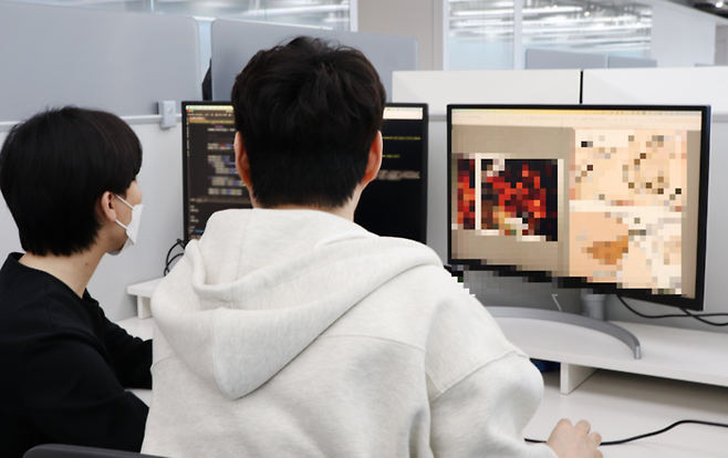 네이버웹툰 AI프로텍션 팀 관계자들이 자체 개발한 AI 필터링 솔루션 ‘엑스파이더’(Xpider)를 통해 유해물이 걸러지는 과정을 살펴보고 있다. [사진=네이버웹툰]