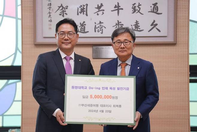 ㈜부산세중 하나투어 대리점 최복룡 대표(왼쪽)가 동명대에 발전기금 500만원을 기탁하고 있다.