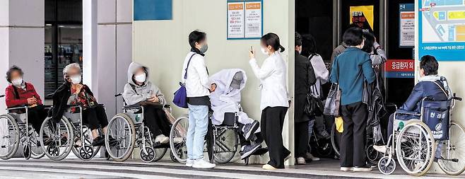 응급실 앞에 줄지어 선 휠체어 행렬 - 24일 휠체어를 탄 환자들이 서울 한 대학병원 응급의료 센터 앞에 줄을 서 진료를 기다리고 있다. 이날 서울대 의대·서울대병원 교수협의회 비상대책위원회는 오는 30일 집단 휴진하겠다고 밝혔다. /뉴스1