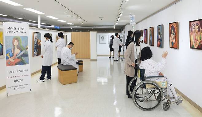 인천 남동구에 있는 가천대 길병원에 설치된 갤러리를 찾은 환자와 보호자, 의료진들이 송미경 작가의 전시회를 관람하고 있다. 가천대 길병원 제공