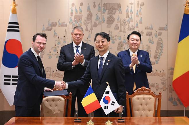 [서울=뉴시스] 윤석열 대통령과 클라우스 베르네르 요하니스 루마니아 대통령이 배석한 가운데 23일 서울 용산 대통령실 청사에서 열린 한·루마니아 원전 협력 MOU 서명식에서 안덕근 산업통상자원부 장관과 세바스티안-이오안 부르두자부 루마니아 에너지부 장관이 양해각서에 서명한 뒤 악수하고 있다. (사진=대통령실 제공) 2024.04.23. photo@newsis.com *재판매 및 DB 금지