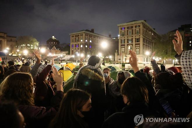 美뉴욕 컬럼비아대의 친팔레스타인 시위대 (뉴욕 로이터=연합뉴스) 지난 23일(현지시간) 미국 뉴욕 컬럼비아대에서 친팔레스타인 시위를 하며 농성하는 학생들이 체포를 무릅쓰고서라도 행동할 수 있느냐는 질문에 손을 들고 있다. 컬럼비아대는 학생들에게 이날 자정까지 해산하라고 최후통첩했다. 2024.4.23