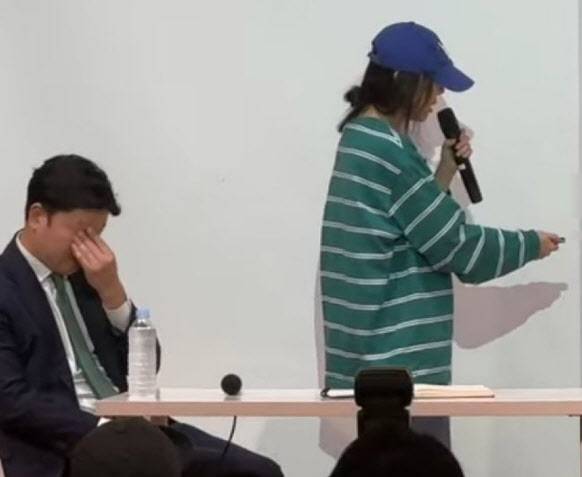 25일 민희진 어도어 대표가 서울 서초구에서 기자회견을 열고 하이브의 '경영권 강탈' 주장에 대해 반박하고 있다. 오른쪽은 민 대표의 발언 도중 이마를 짚고 있는 법무법인 세종의 변호사. 엑스(X) 캡처