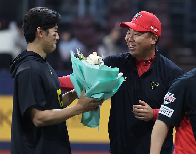 이범호 KIA 감독이 25일 고척 키움전에서 KBO 최초 월간 10홈런-10도루 기록을 세운 김도영에게 꽃다발을 건네고 있다. 연합뉴스