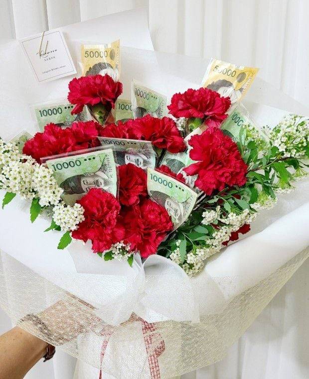 카네이션 생화를 지폐로 한 송이씩 감싸 만든 어버이날용 '돈 꽃다발'. /페이스북