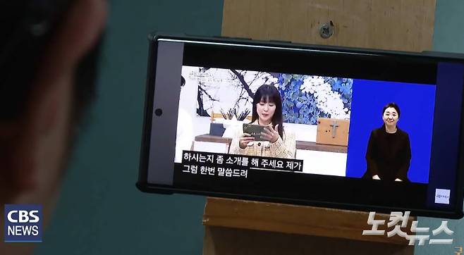 CBS의 '새롭게하소서' 수어통역 콘텐츠를 시청하고 있는 모습. 2분할 화면으로 수어통역을 보기 쉽게 제공하고 있다. 청각장애인들은 TV 화면 하단에 나오는 작은 수어 통역이 잘 보이지 않아 어려움을 겪는 경우가 많다고 말한다.