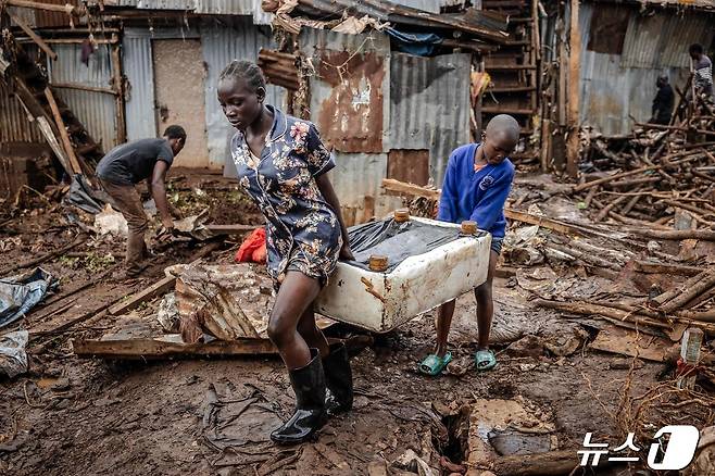 25일(현지시간) 케냐 나이로비의 한 마을에서 두 어린이가 홍수로 파괴된 집에서 살림살이를 꺼내 옮기고 있다. 2024.04.25/ ⓒ AFP=뉴스1 ⓒ News1 권진영 기자