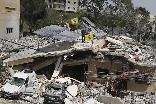 [하난(레바논)=AP/뉴시스]레바논 남부 하난 마을에서 25일 한 남성이 이스라엘군의 공습으로 파괴된 집 위에 서 있다. 레바논의 무장단체 헤즈볼라를 향한 이스라엘의 폭격이 27일에도 계속되면서 남부 사르빈 마을에도 미사일 공격이 가해졌다고 레바논군 소식통이 밝혔다.  2024.04.28.