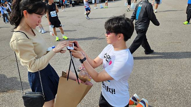 28일 서울하프마라톤 10km를 완주한 안현우씨가 이수민씨에게 청혼하는 모습. /박진성 기자