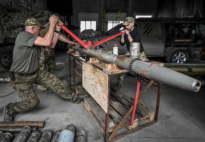 26일(현지시간) 우크라이나 자포리자주에서 고령자 의용군 부대인 ‘초원의 늑대들’ 대원들이 BM-21 그라드 다연장 로켓용 포탄을 개조하고 있다. 로이터연합뉴스