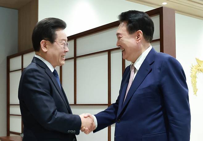 윤석열 대통령이 29일 서울 용산 대통령실에서 열린 영수회담에서 집무실에 도착한 이재명 더불어민주당 대표를 맞이하며 악수하고 있다. [연합]