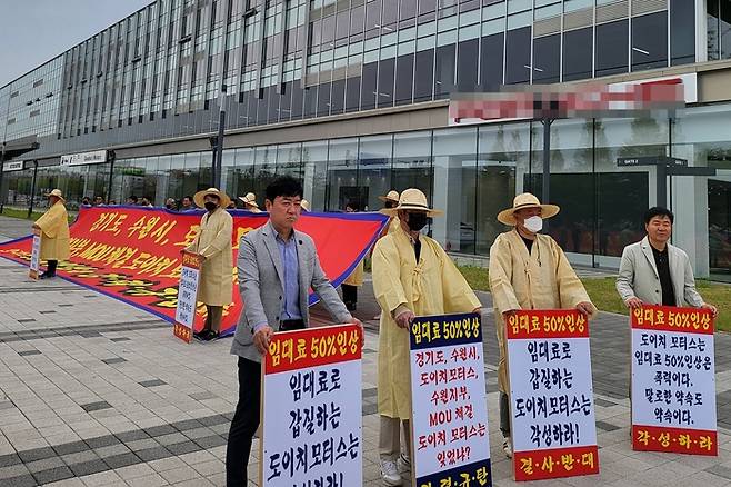 29일 오전 수원시 권선구 고색동에 위치한 도이치오토월드 중고차매매단지 앞에서 수원자동차매매협동조합 조합원들이 도이치오토월드 측의 임대료 인상 방안에 반대하는 집회를 열고 있다. /수원자동차매매협동조합 제공