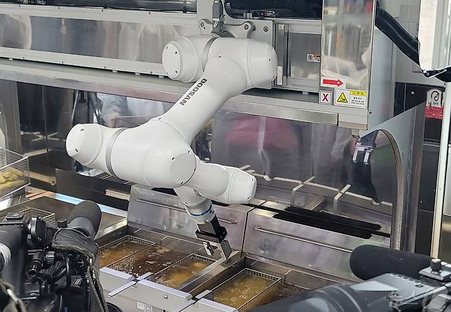 두산로보틱스 협동로봇이 단체급식 튀김작업을 수행하고 있다.(두산로보틱스 제공)