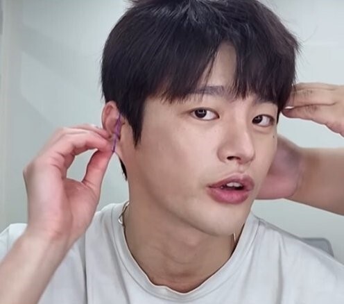 가수 서인국이 고무줄을 귀에 거는 방법을 소개하고 있다. 서인국 유튜브 화면 캡쳐