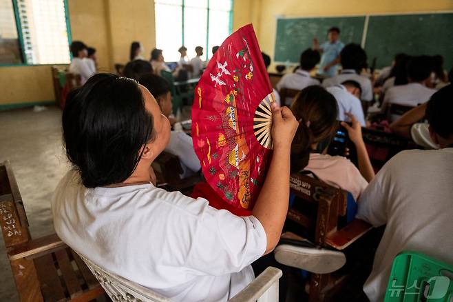 필리핀 메트로마닐라 퀘존시티의 한 고등학교에서 한 학생이 더위를 식히기 위해 부채질을 하고 있다. 2024.04.18 ⓒ 로이터=뉴스1 ⓒ News1 정지윤 기자